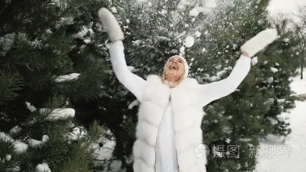 迷人的金发女郎玩雪的冬季风景背景