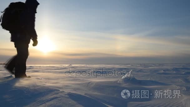 一名男子走过一场暴风雪在白雪皑皑的原野