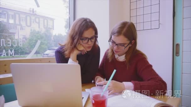 女大学生学生研究在咖啡馆两女孩朋友一起学习