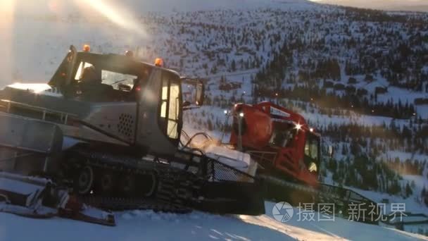 人们开车在日落时分在特利西尔，挪威准备滑雪斜坡的雪堆机器