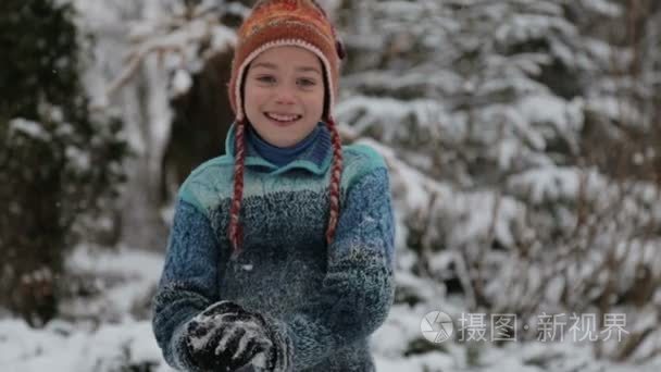 一个孩子在雪地里公园里玩。冬天外面一男婴的画像。男孩玩雪，把一个雪球扔着相机的镜头