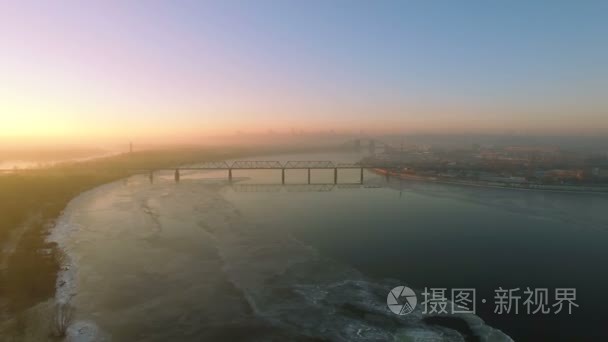 4 k 空中。城市的冰冻的河和桥在日出、 日落的冬季景观。全景