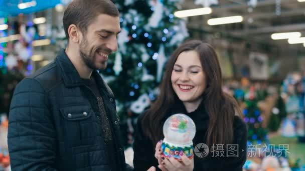 夫妇与雪花玻璃球在商店视频
