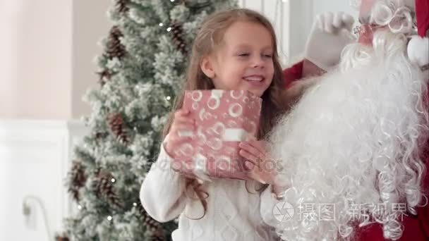 快乐的小微笑女孩试图猜测里面她来自圣诞老人的圣诞礼物是什么