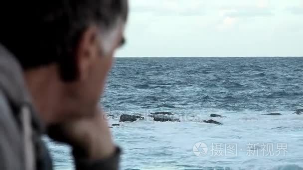 五十岁的人注意到波涛汹涌的海面