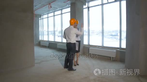 专业的工程师和建筑师-检查未完成的工业建筑，施工现场团队