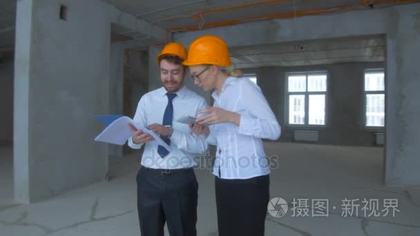 专业的工程师和建筑师-检查未完成的工业建筑，施工现场团队