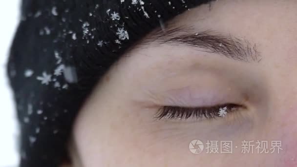 雪花落在女孩的眼睛在慢动作视频