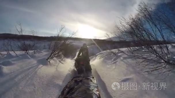 雪地摩托骑雪路上背景喷发火山视频