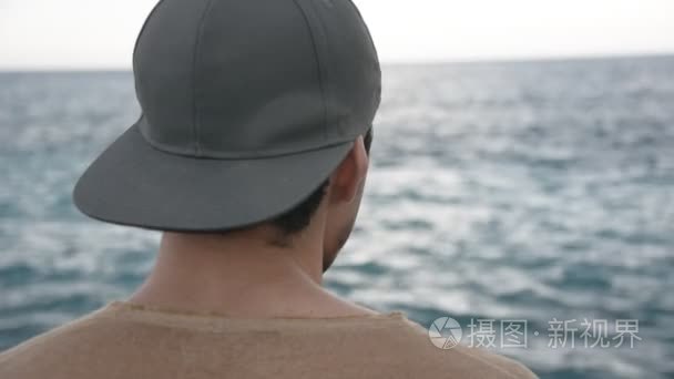 年轻男人写作和思维在前面的海视频