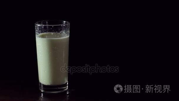 在黑色背景上的玻璃的美味和健康牛奶