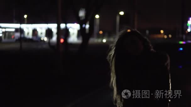 女孩站在大街上的车在晚上视频