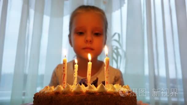 女孩吹灭蜡烛的生日蛋糕庆祝他的生日上
