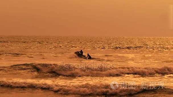波转轮切碎了大海，用上它的两个男人的光明的看法。巴厘岛夕阳与棕褐色的水和天空在阳光明媚的户外与自然背景的图片