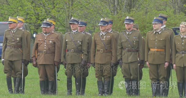 波兰国旗日在奥波莱步兵和车手士兵站成两行的车手路过军排练上游行在绿色的田野度假