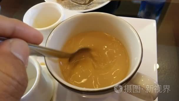 手在白色的杯子里搅动咖啡视频