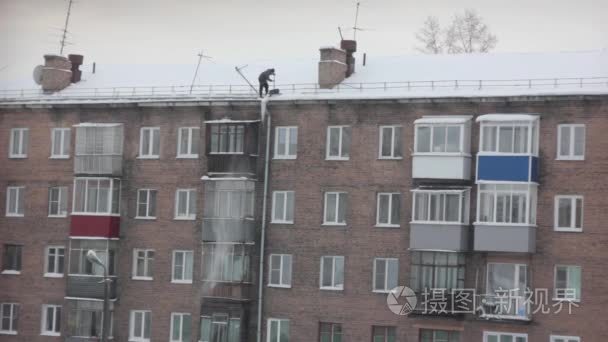 一名工人清理从屋顶雪视频