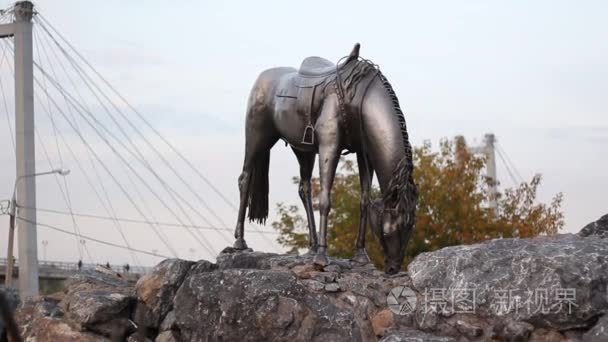 这匹马的纪念碑低下他的头大桥为背景，在一个公园内
