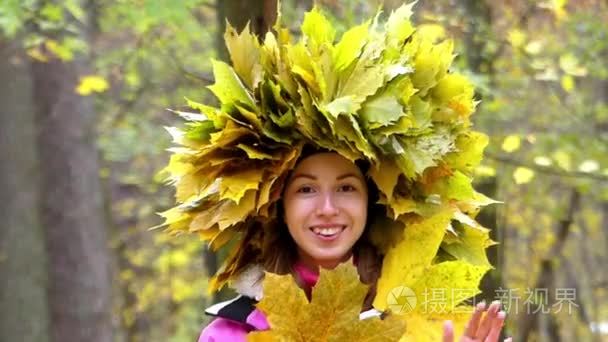 漂亮的女孩中使用的黄色的叶子在她头上的花环挂在林中捉迷藏