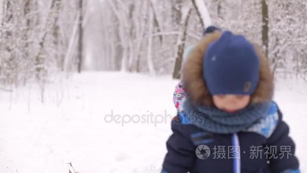 两个小孩玩雪的冬季公园视频