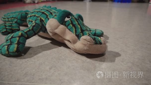 玩具绿色鳄鱼躺在地板上视频