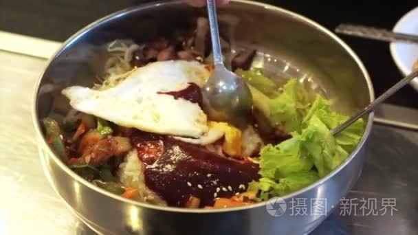 石锅拌饭韩国人以米饭和什锦蔬菜食品菜用不锈钢勺子混合