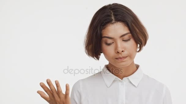 年轻美丽的黑发东亚女性穿衬衫不赞成在慢动作中的白色背景上短视频