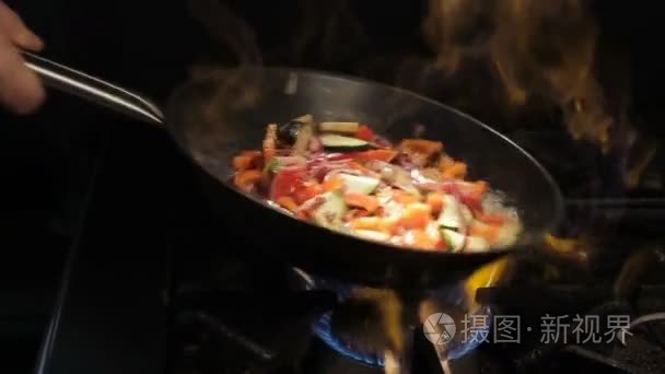 人摇盘以上明火上切好的蔬菜视频