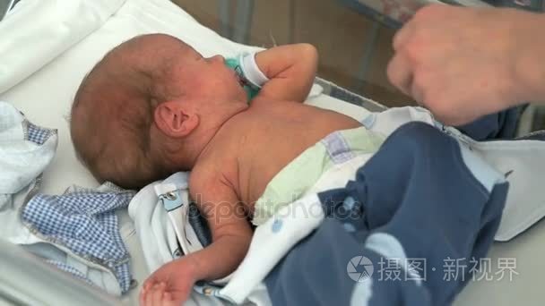 医疗护士层层刚出生的婴儿在婴儿床上