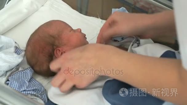 医疗护士层层刚出生的婴儿在婴儿床上