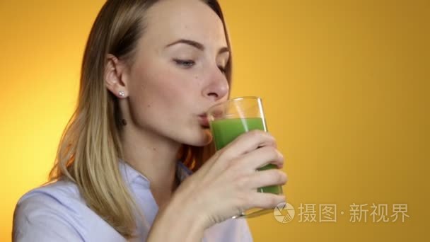 年轻女人喝绿色蔬菜思慕雪