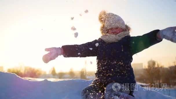 一个女孩抛雪她头顶上日落背景