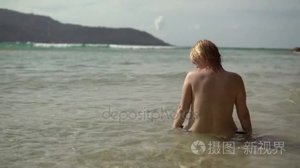 年轻性感的女人在海边晒日光浴