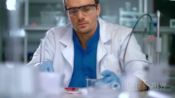 科学家在实验室做医学研究。实验室工作人员倒液体