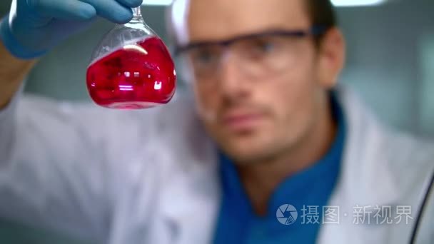 在科学家手中的液体玻璃烧瓶。在实验室中的医学研究