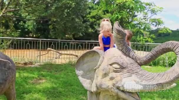 小女孩坐在大象雕塑视频