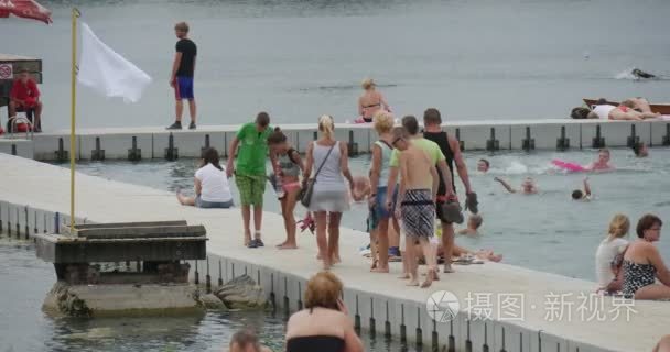 Pisturesque 白色混凝土专用码头湖 Bolko 与大量的游客，在夏天白天看着蓝色的海水和白色的标志视频