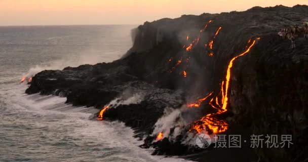 游客看着火山喷发熔岩流入海洋视频