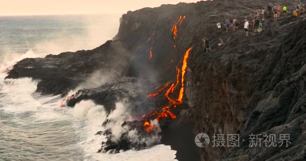 游客看着火山喷发熔岩流入海洋视频