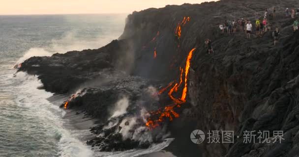 游客看着火山喷发熔岩流入海洋视频