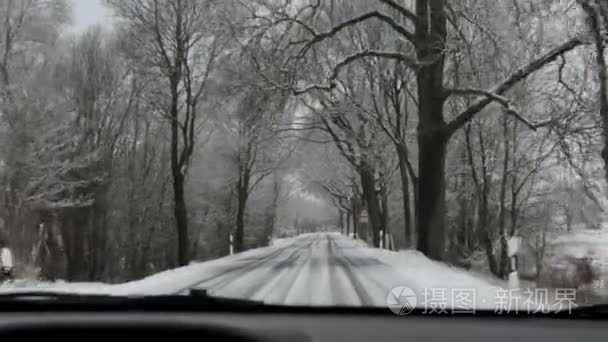 在冬天的时候开车沿着一条路。白雪皑皑，湿滑