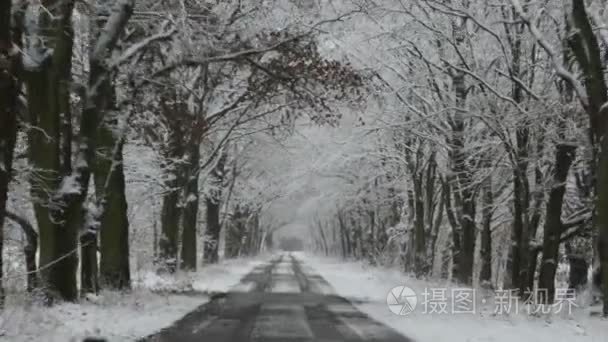 在冬天的时候开车沿着一条路。白雪皑皑，湿滑