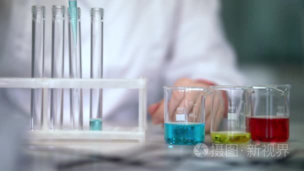 实验室玻璃器皿中的液体的科学家。填充液体的试管