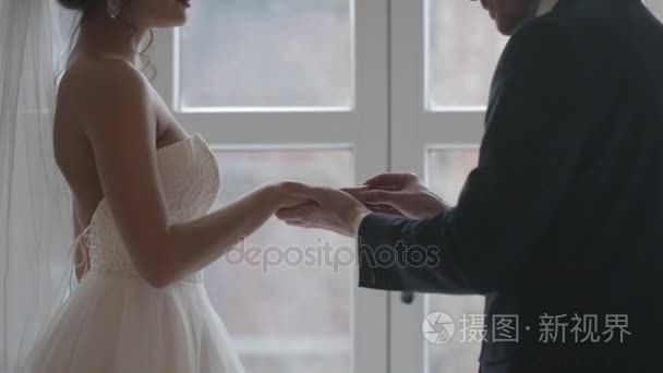 新郎把新娘的手指上的戒指视频