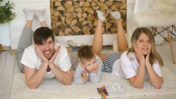 可爱的家庭构成和在他们的客厅里地板上微笑的画像视频