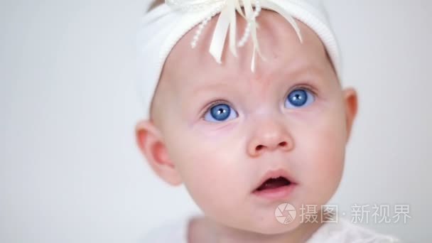 女婴的白色的裙子和头巾坐视频