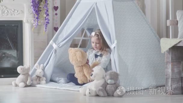 可爱的小女孩金发坐包围软玩具视频