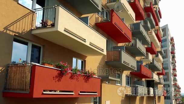 米色的公寓楼与多彩 （红色、 灰色、 黄色） 阳台和低于在城市地区，在背景中的灰色公寓楼入口