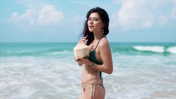 在海滩上喝椰子的美丽女孩视频
