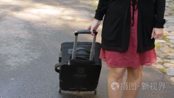 手提箱包在轮子上的女人视频